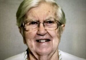 A woman with glasses and white hair.