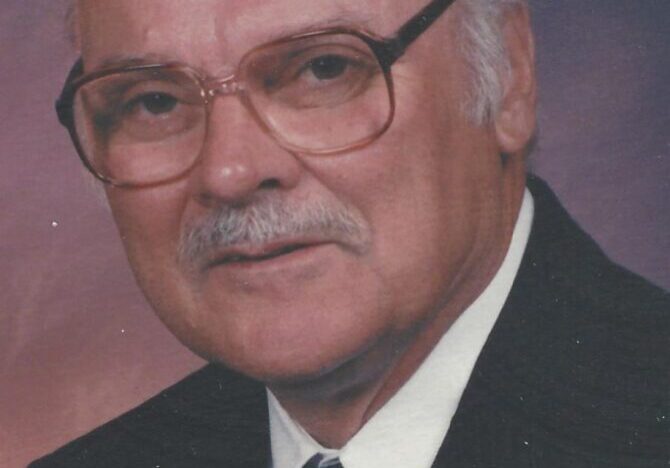 A man with glasses and a suit on.