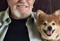 A man and his dog are smiling for the camera.