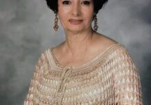 A woman in a white dress and black hair.