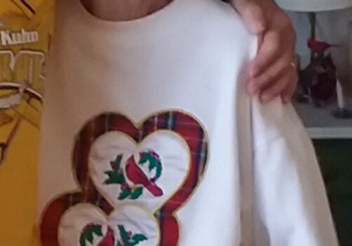 A woman in a white sweater with two hearts on it.