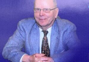 A man in a suit and tie sitting at a table.