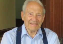 An older man wearing a blue shirt and suspenders.