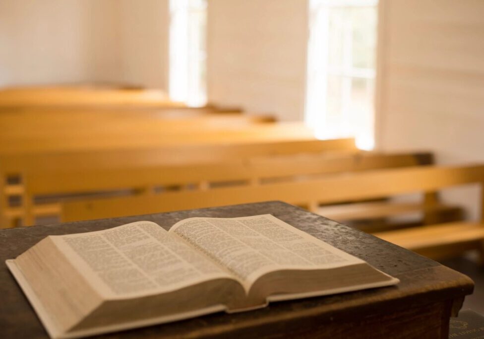 A book is open on the table in front of some benches.