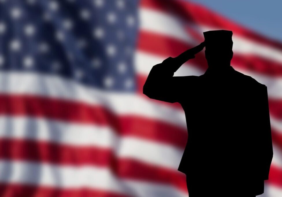 A soldier saluting in front of an american flag.